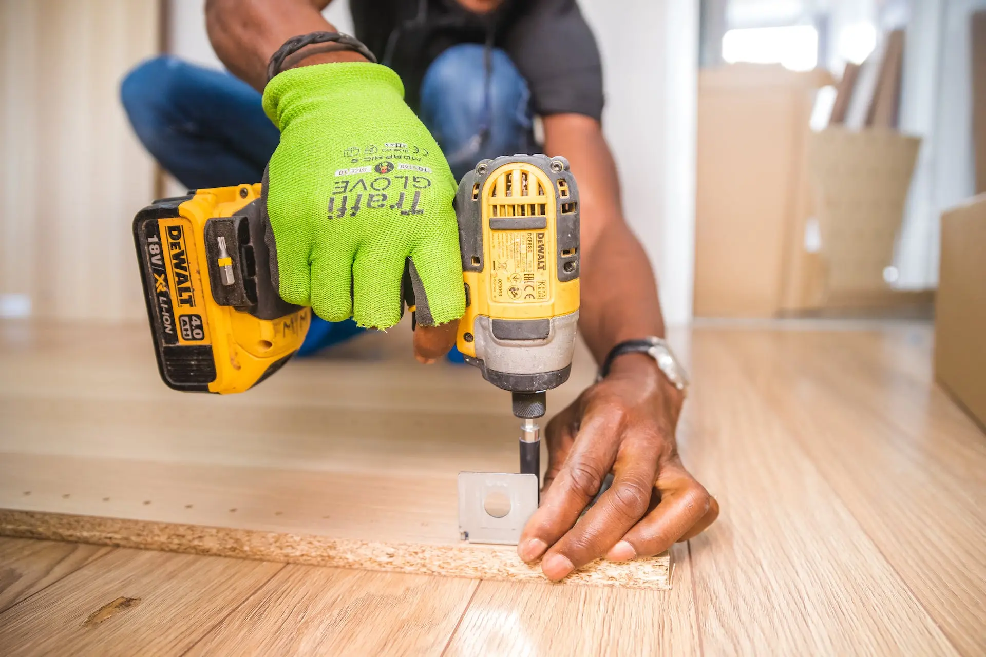 Person using a cordless drill on a wooden piece