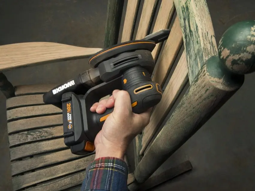 Using a detailed sander on a wooden chair