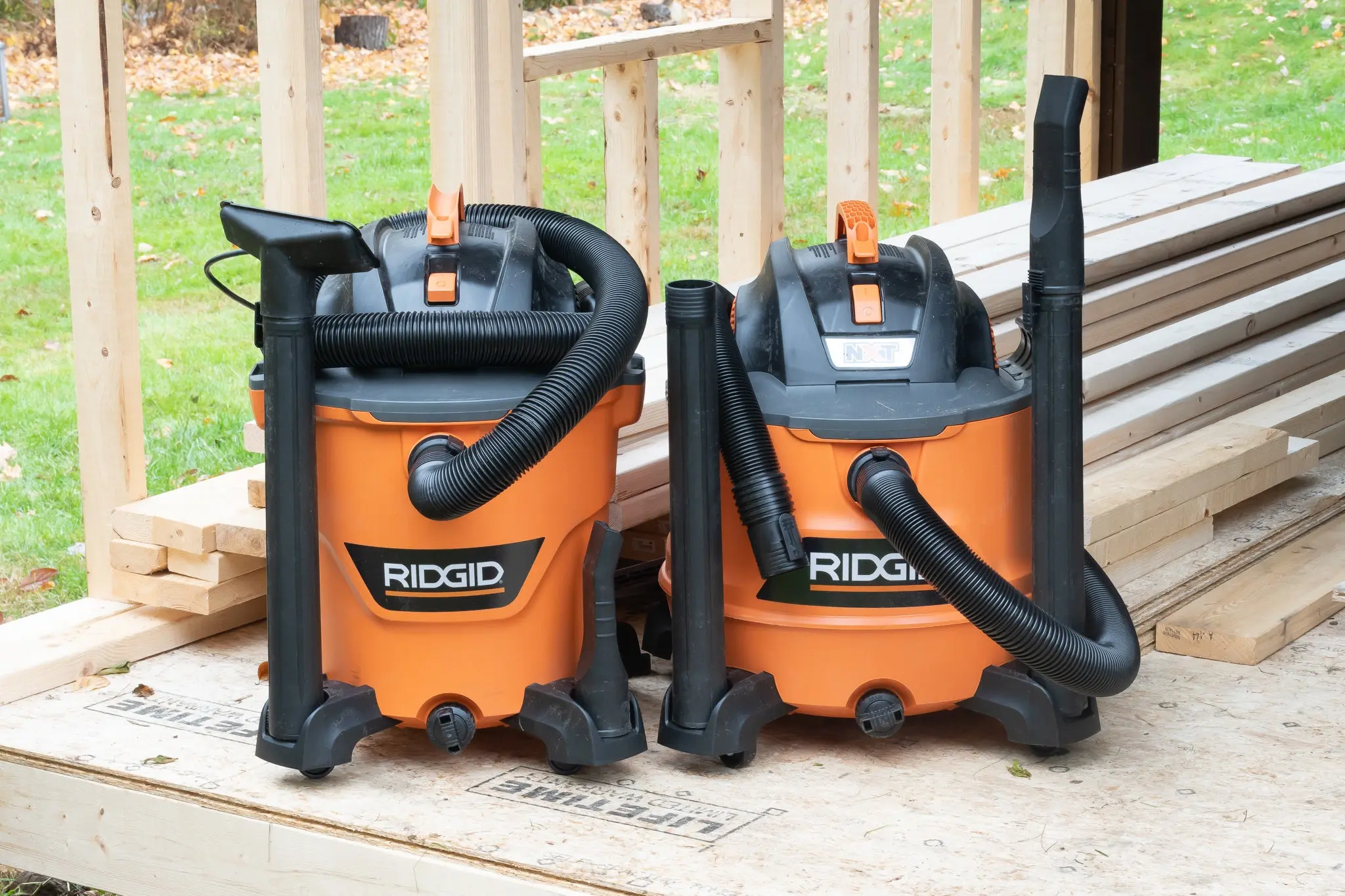 Two orange shop vacuums on porch